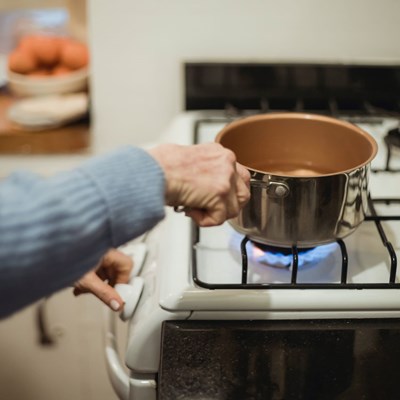 A stock photo of someone using a gas hob
