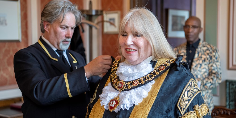 The Lord Mayor being fitted with her chain of office in the Town Hall