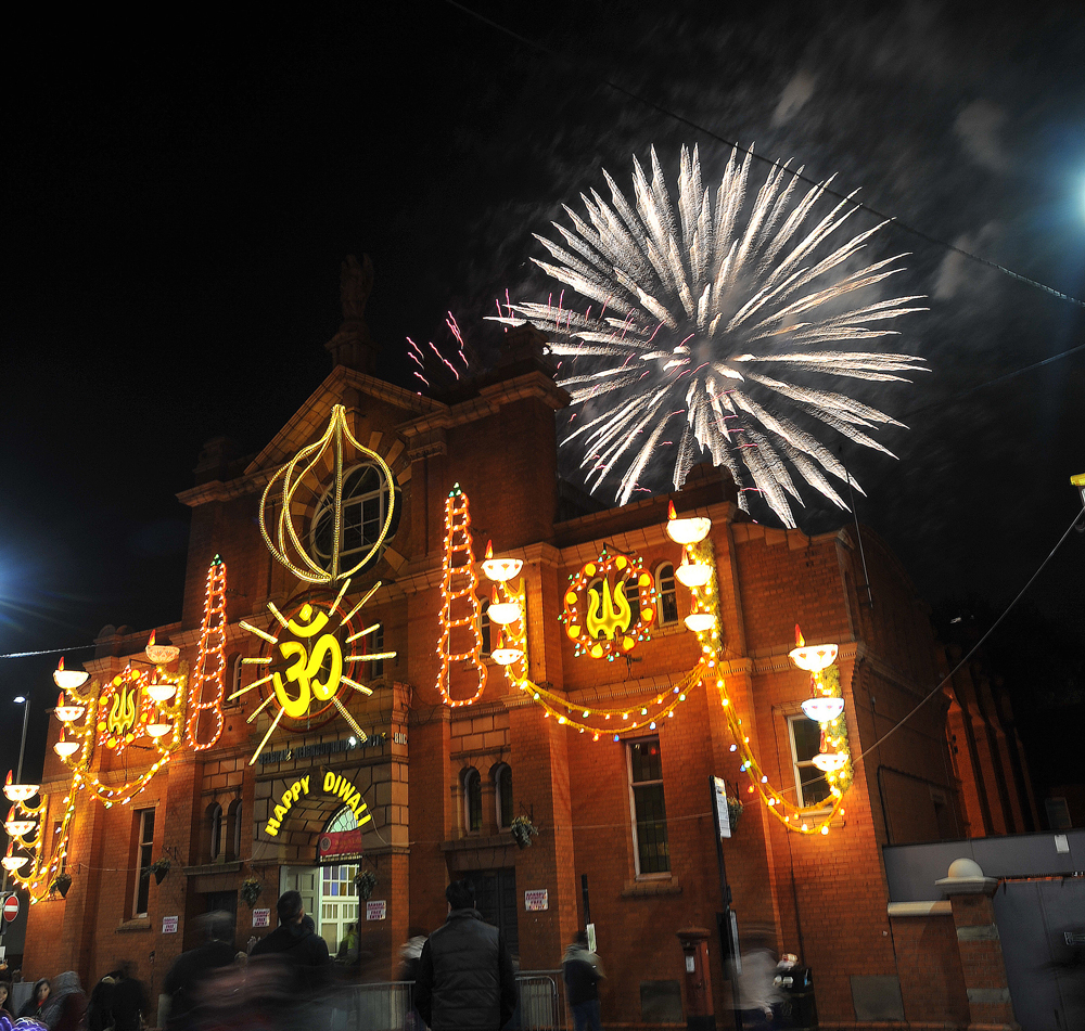 Fireworks in front of Belgrave Neighbourhood Centre which has Diwali lights across it.