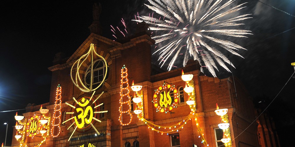 Fireworks in front of Belgrave Neighbourhood Centre which has Diwali lights across it.