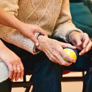 Carer holding hand of elderly person