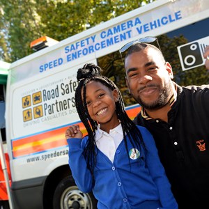 Parent and child with police safety camera van