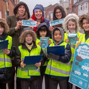 School children and staff with clipboards outside school