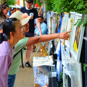 People looking at art on the riverside
