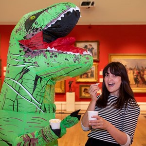 Dinosaur and staff member share popcorn