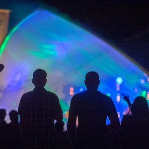 Silhouettes of people watching live music