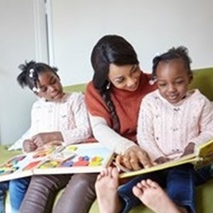 Image shows a family group looking at picture books together