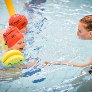 Children with instructor in swimming pool