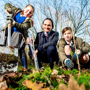 Image shows Cllr Adam Clarke planting trees with Montrose Primary School pupils