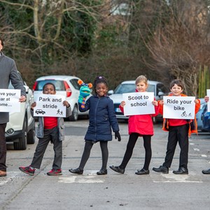 Picture shows Cllr Adam Clarke (left), and headteacher Lou Harrison (right) with 'Clean Air Clive' and children from King Richard III Infant School.