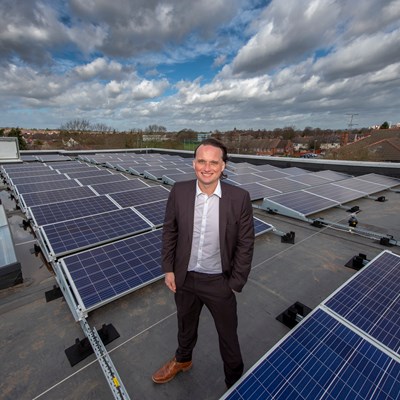 Cllr Clarke and solar panel array at Leicester school