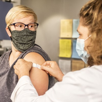 Woman is injected in the arm with vaccine