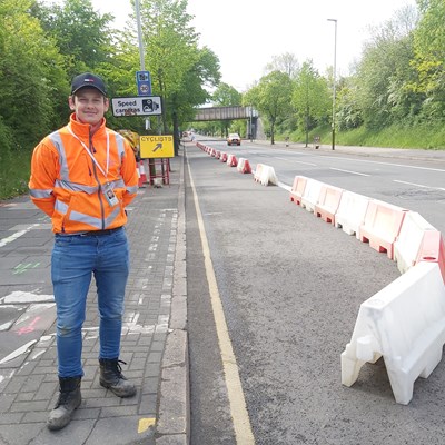A transport worker stands by the new temporary cycle lane on Saffron Lane