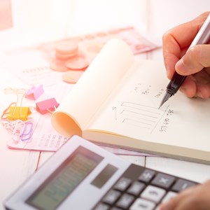 Person using a calculator and notepad
