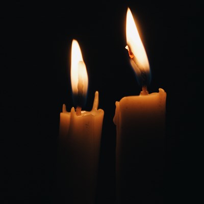 Two candles burning in darkness