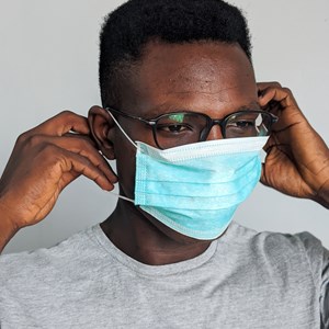 Stock picture of a man putting on a face mask