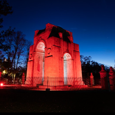 Arch of Remembrance lit red at dusk