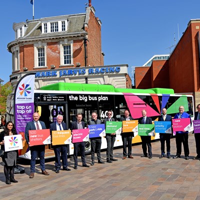 Representatives of the new Leicester Buses Partnership pose with a branded bus