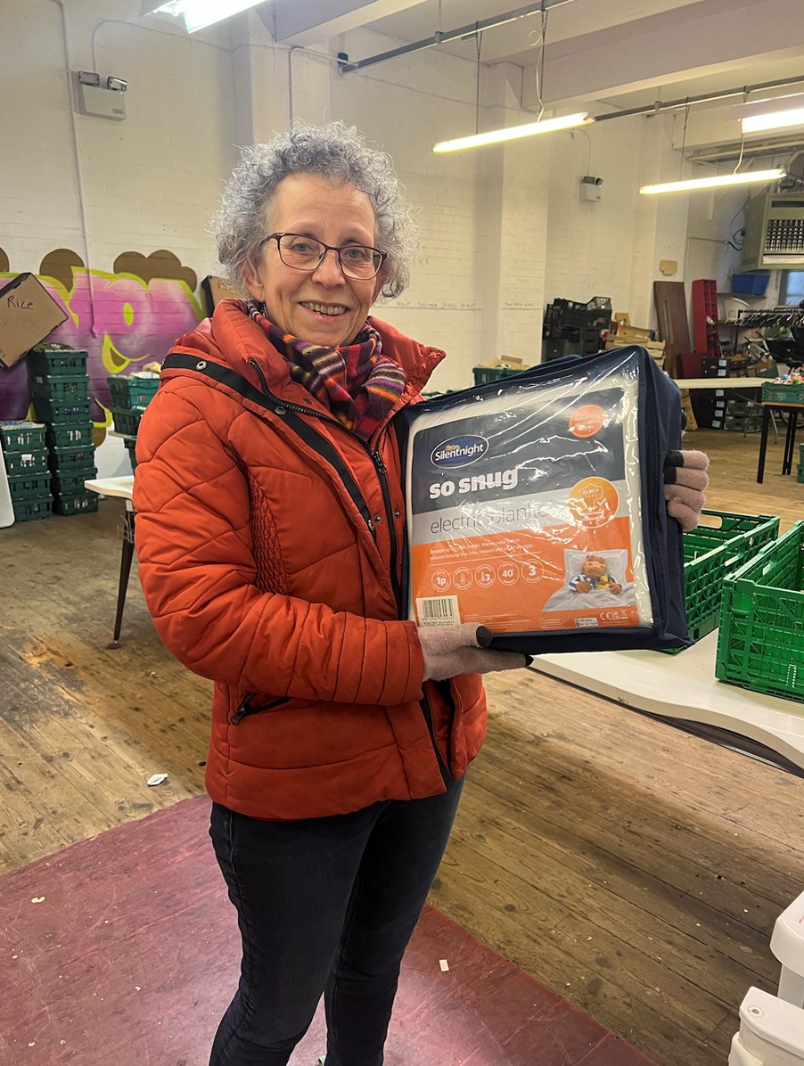 Chair of Woodgate Community Food, Eve Hill, with one of the blankets