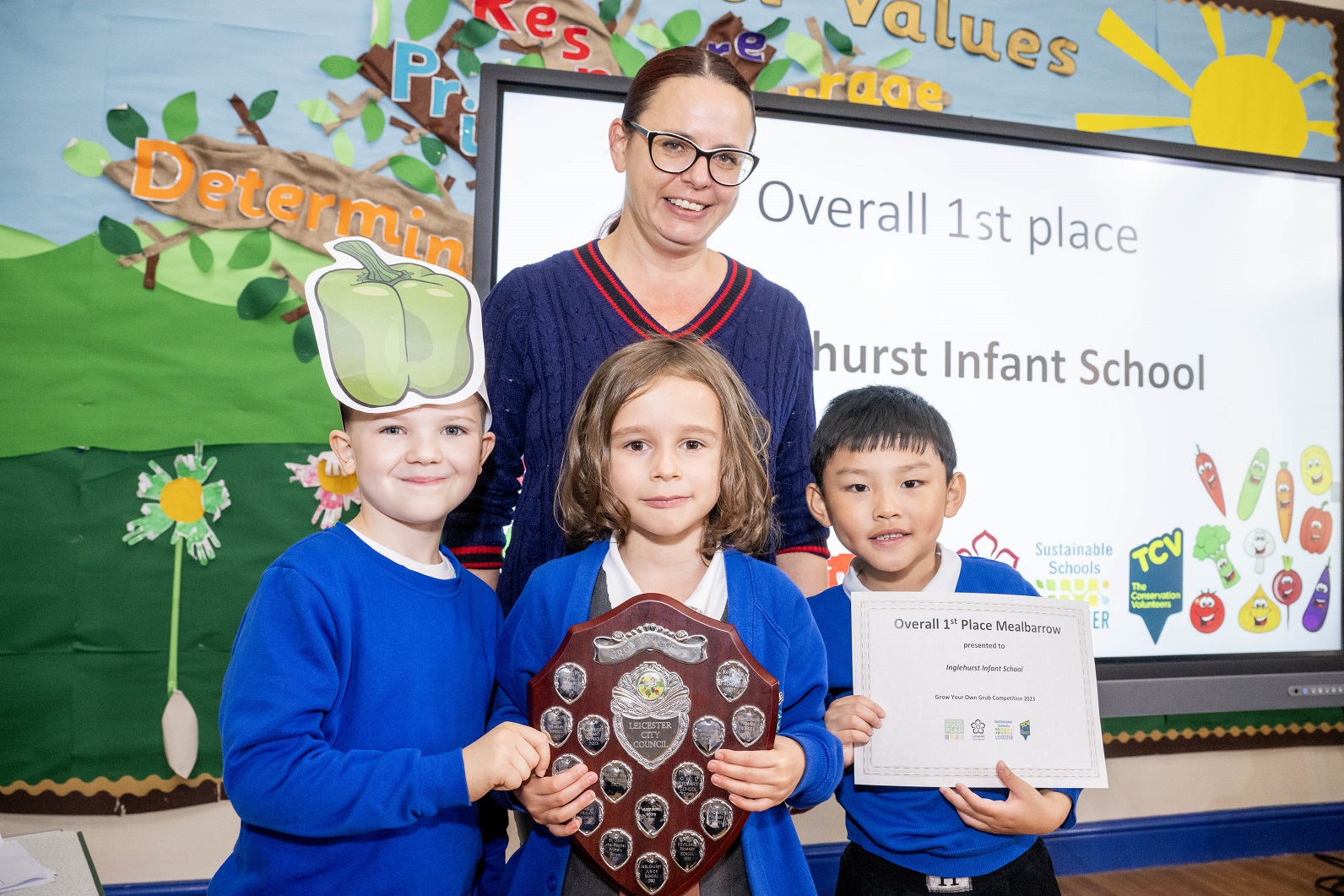 Parent volunteer and pupils accepting an award