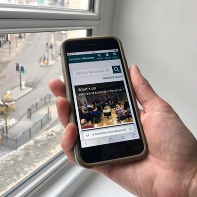 A picture of the new libraries website on a mobile phone