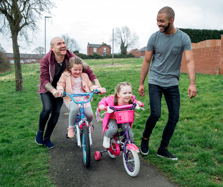 A couple with children to illustrate LGBTQ+ couples who foster or adopt