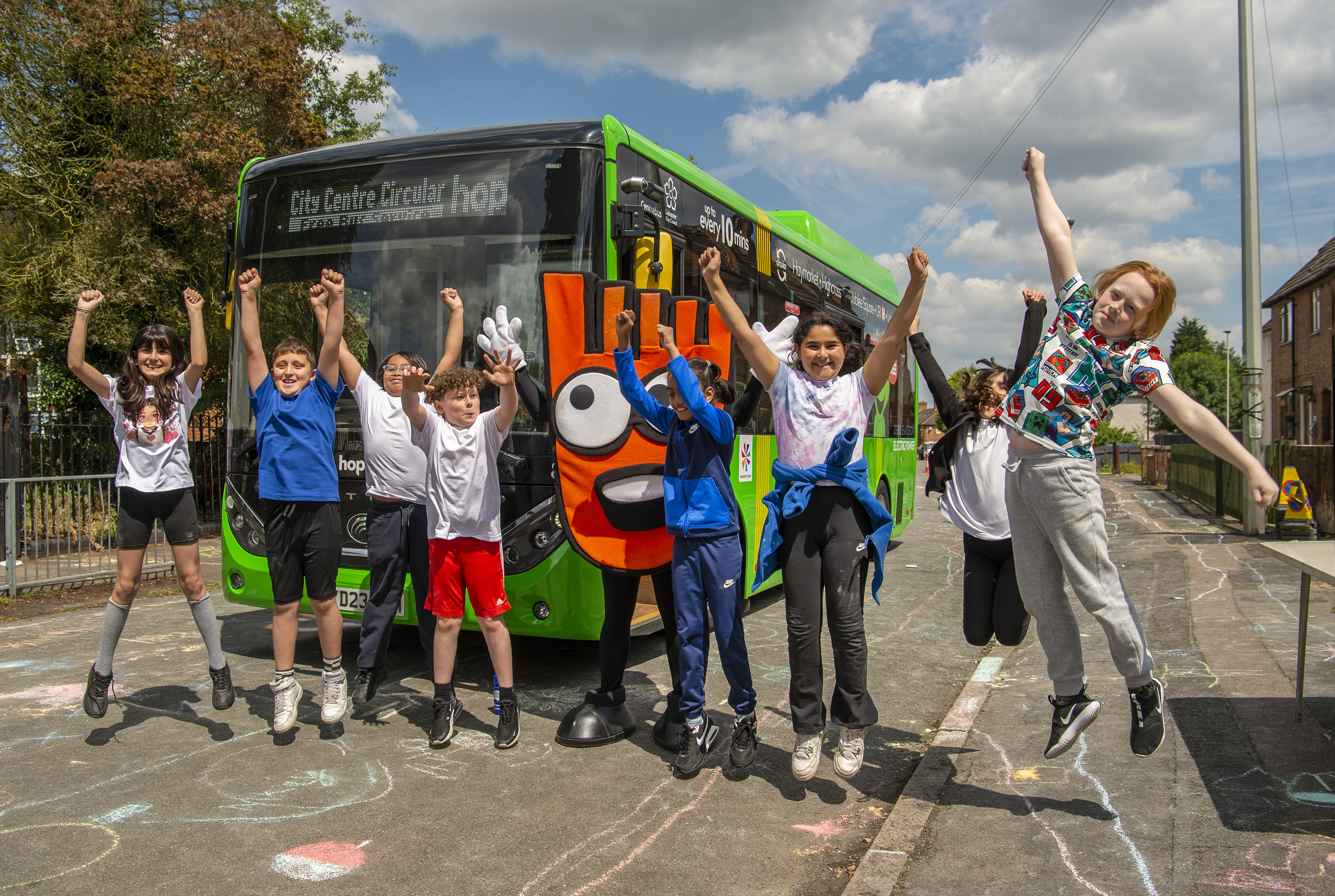 Picture shows schoolchildren taking part in last year's Clean Air Day with the electric Hop! bus and Strider the walking mascot
