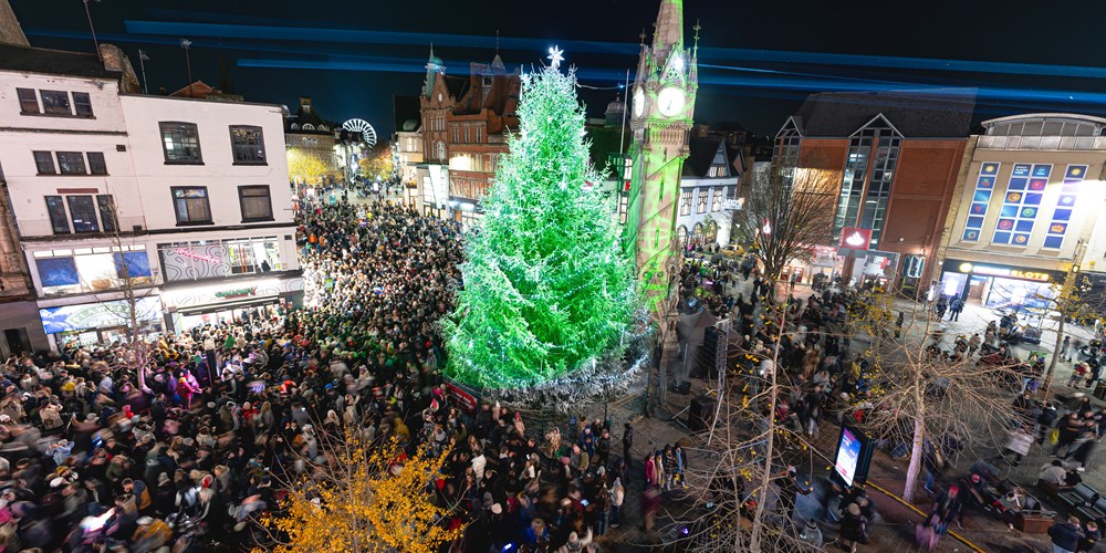 BUSINESSES in Leicester are being asked to help to fill the city with Christmas cheer by sponsoring Christmas trees that will light up public spaces or their own premises, throughout the festive season. 50 foot Christmas tree stands next to Leicester Clock Tower surrounded by huge crowds of people.