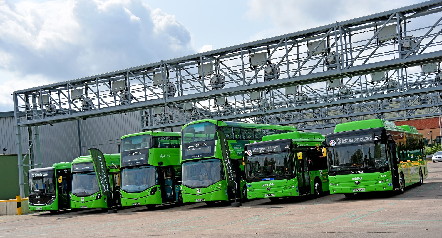 Green electric buses in a line.